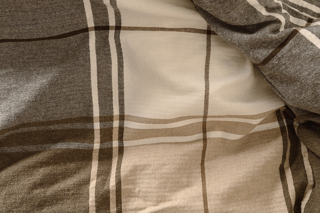 A brown, gray, and white plaid duvet.