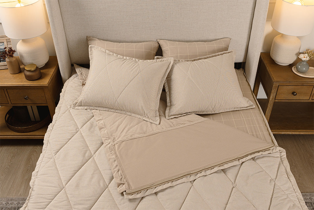 Overhead photo of tan striped quilted zipper bedding with tan and white grid bed sheets and tan corduroy minky interior.