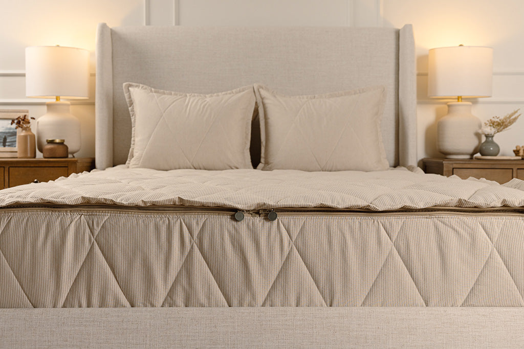 End of bed showing double zippers on tan stripe quilted zipper bedding.