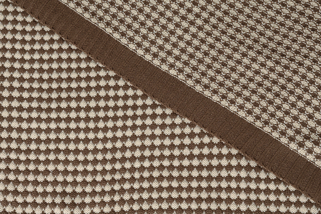 A photo that shows the brown and cream scallop weave color and texture of throw blanket.