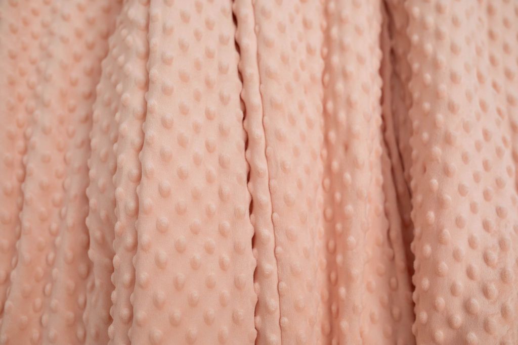 A close up of a softly textured peach minky blanket.