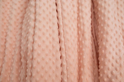 A close up of a softly textured peach minky blanket.