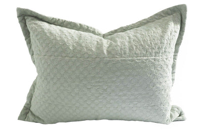 A light green textured sham pillow.
