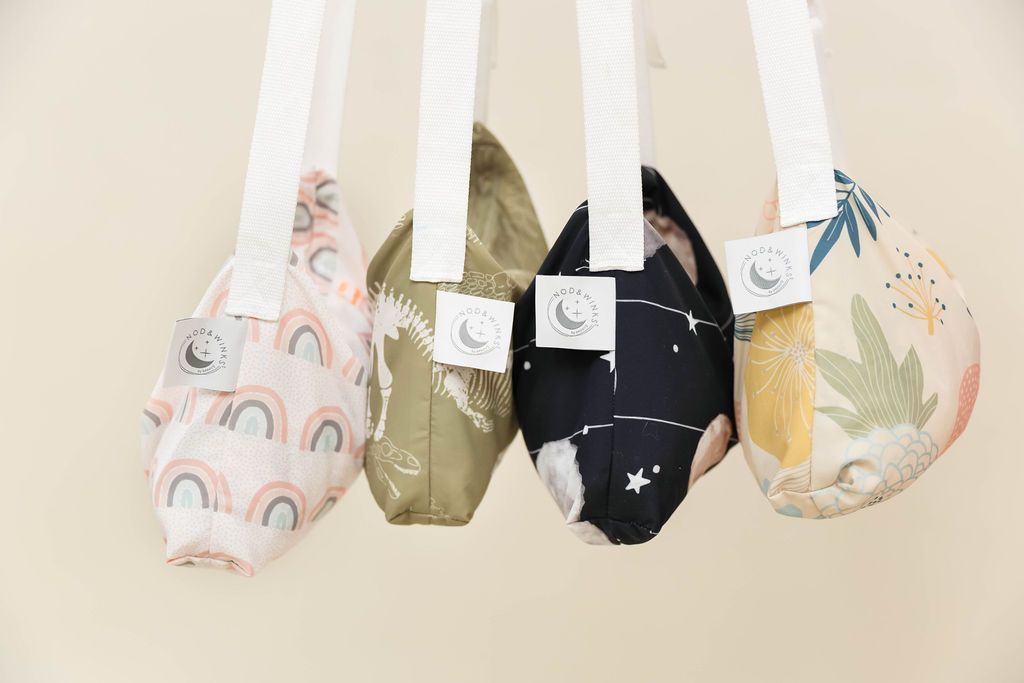 4 bags holding children's blankets inside hanging in a row