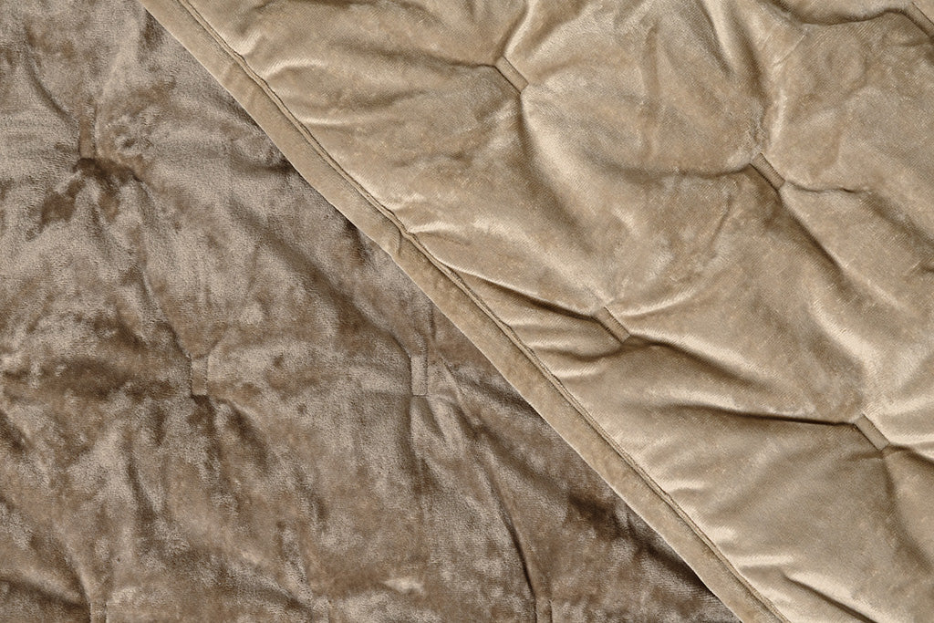 A flat lay of a tan velvet textured blanket.