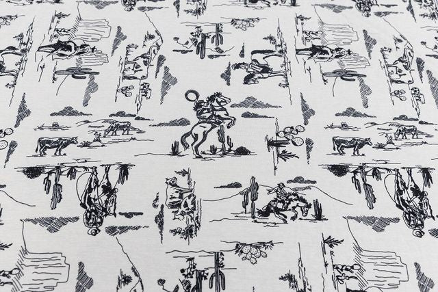 A close up view of a white and black western printed blanket. 
