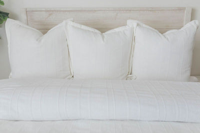 White duvet bedding with matching white pillows on bed