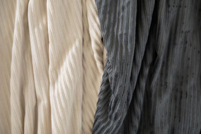 A close up view of softly textured light tan and charcoal gray minky blankets.