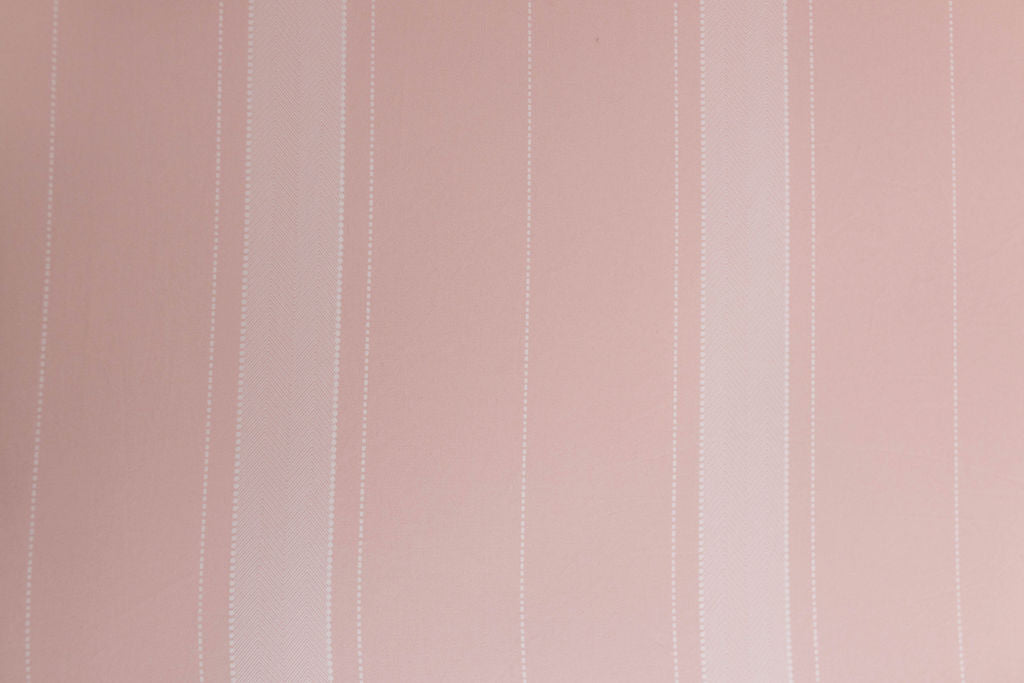 A close up view of a pink striped interior lining of a pink zipper bedding.