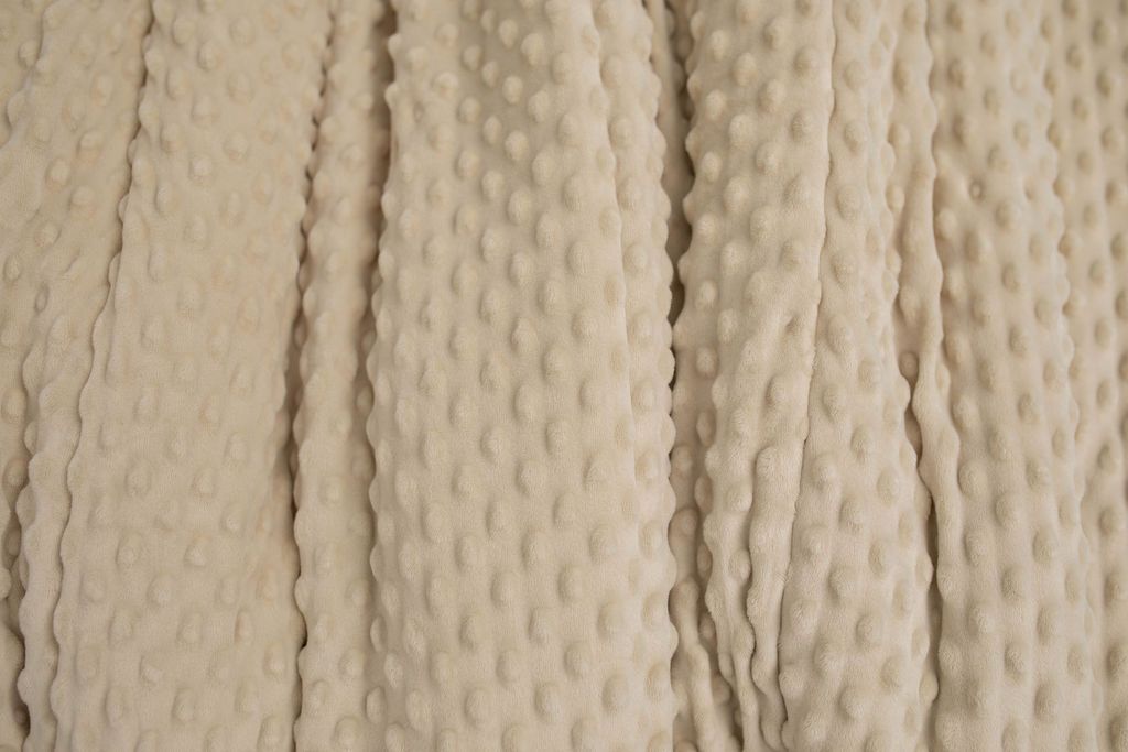 A close up of a tan softly textured minky blanket.
