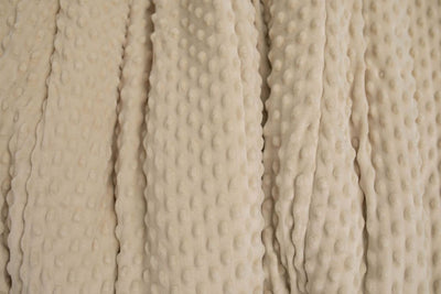 A close up of a tan softly textured minky blanket.
