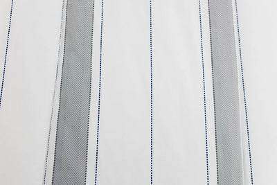 A close up view of a gray and white striped blanket. 