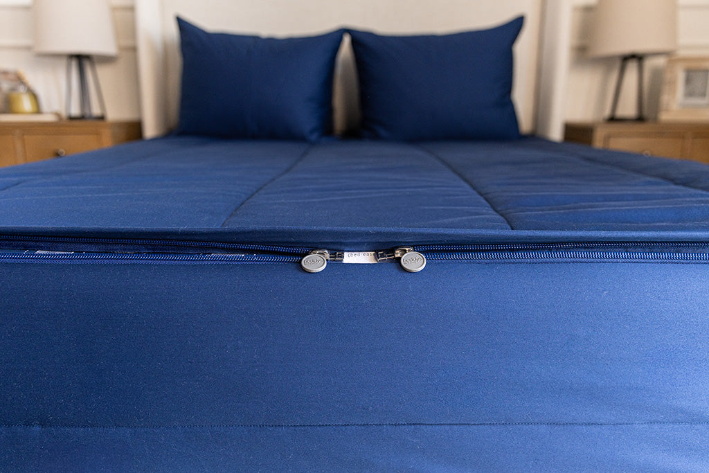 End of bed showing double zippers on blue zipper bedding.