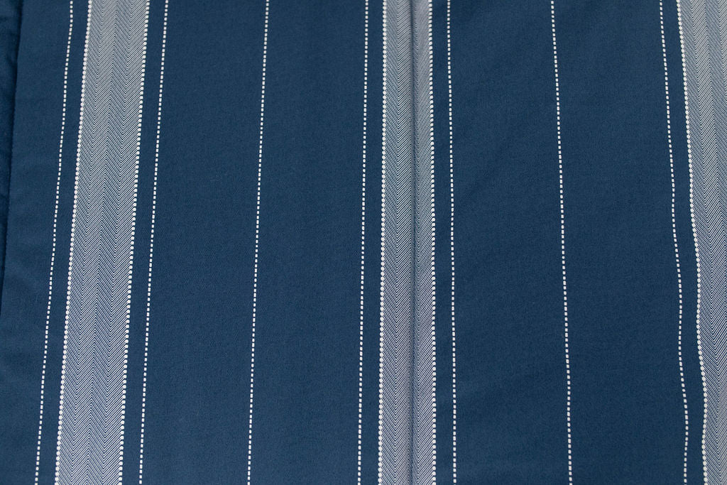A close up detailed view of the gray striped interior of a navy blue zipper bedding.