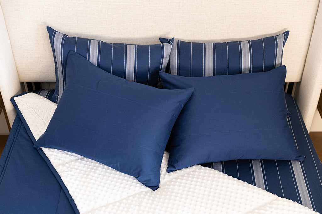 Overhead photo of navy blue zipper bedding with navy blue bed sheets and white minky interior.
