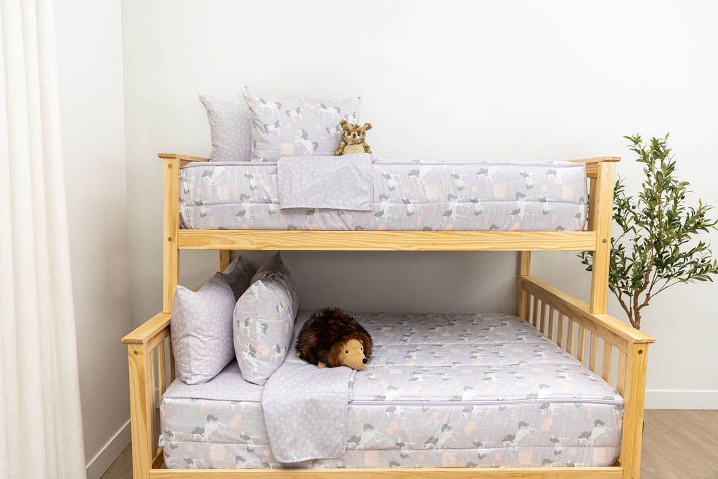 A bunk bed where both bunks are made with purple unicorn kids zipper bedding