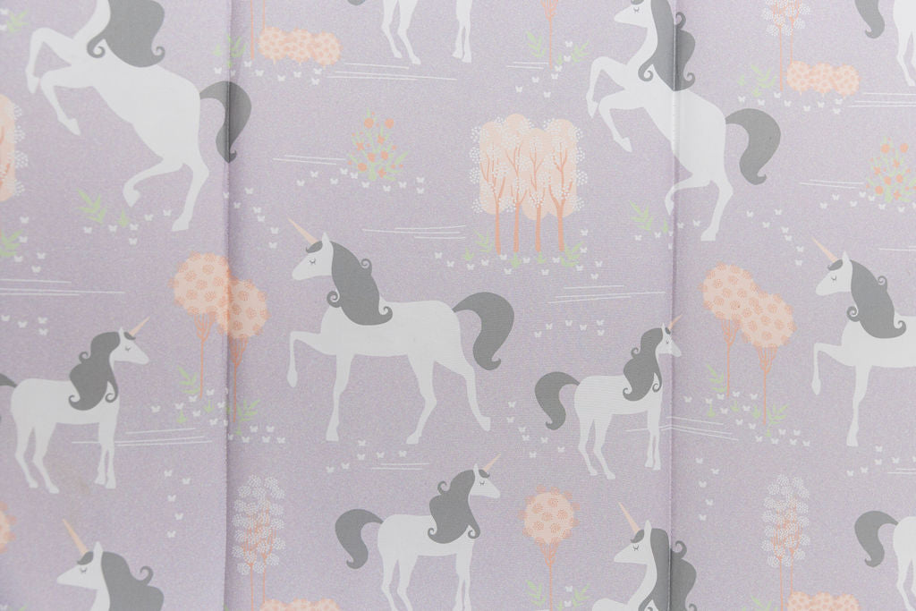 A close up of the print on a set of purple unicorn kids zipper bedding