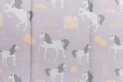 A close up of the print on a set of purple unicorn kids zipper bedding