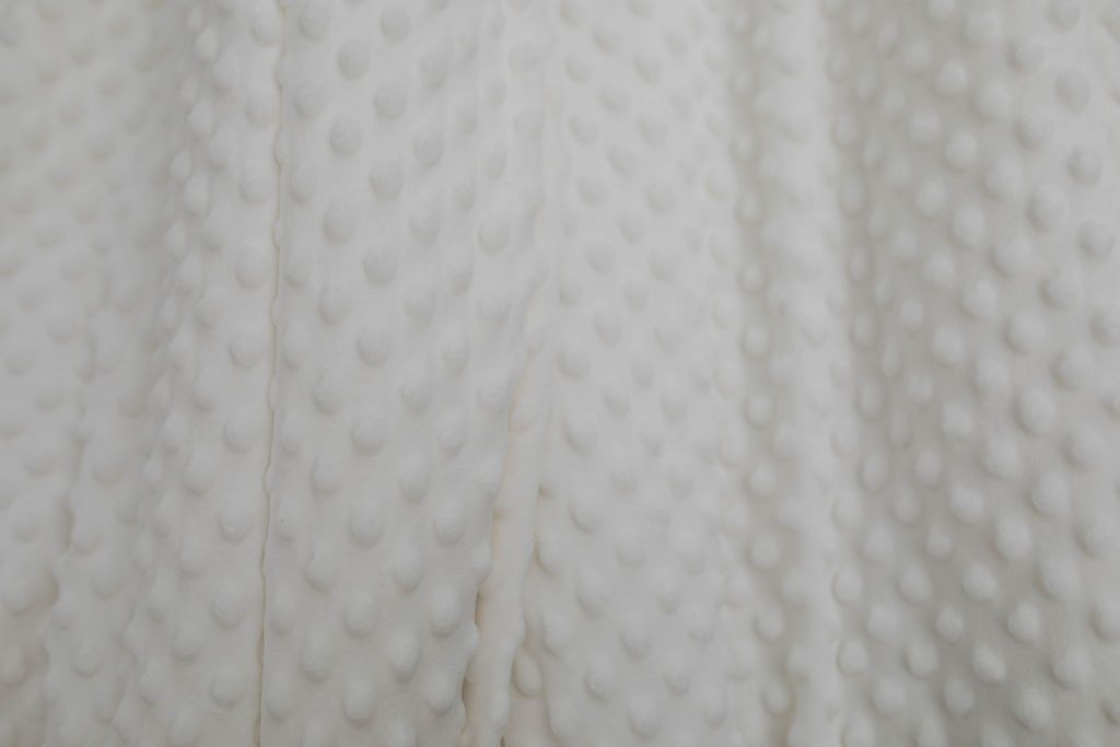 A close up of a softly textured white minky blanket.