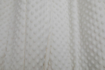 A close up of a softly textured white minky blanket.