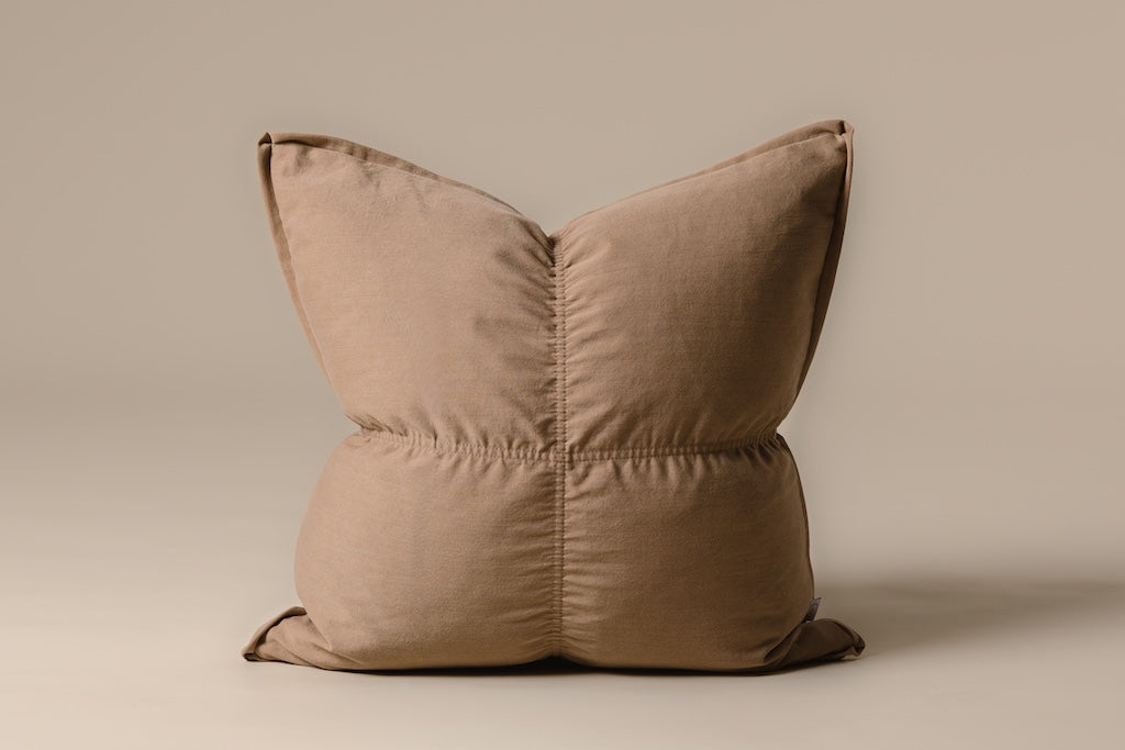 Light brown medium pillow on a cream backdrop.