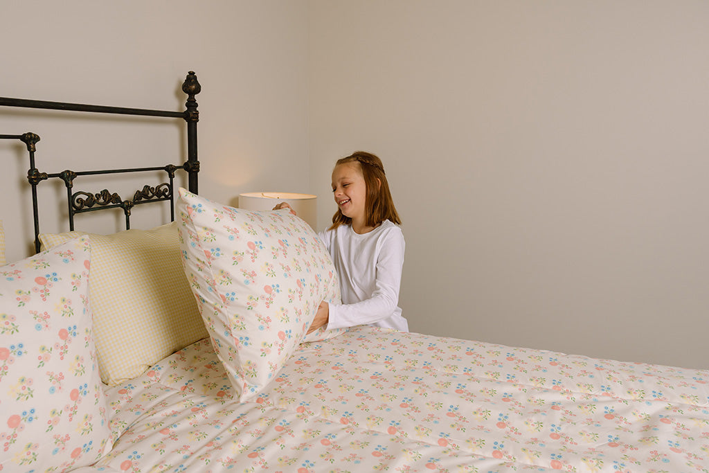 A girl making her gingham and floral zipper bedding.
