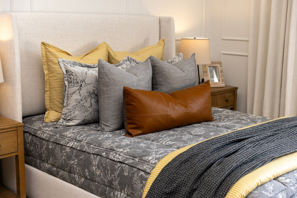 A cream sketched floral pattern with a charcoal base zipper bedding with gray, yellow and rustic accessories.