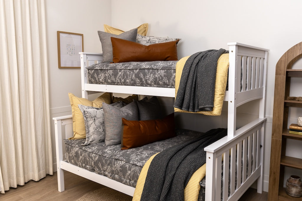 A bunk bed made with sketched floral zipper bedding with gray, yellow, and rustic accessories.
