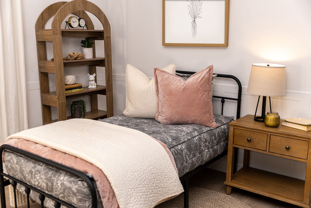 Twin bed with sketched floral zipper bedding with cream and pink accessories.