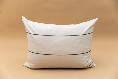 A cream and gray striped pillowcase on tan background. 
