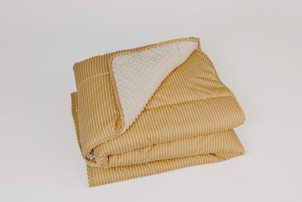 Yellow and cream stripe blanket with folded corner showing cream minky.