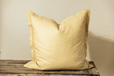 Yellow and white striped xl euro pillow cover on cream background.