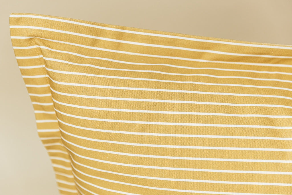 Yellow and white striped xl euro pillow cover on cream background.