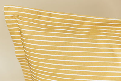 Yellow and white striped xl euro pillow cover on cream background.