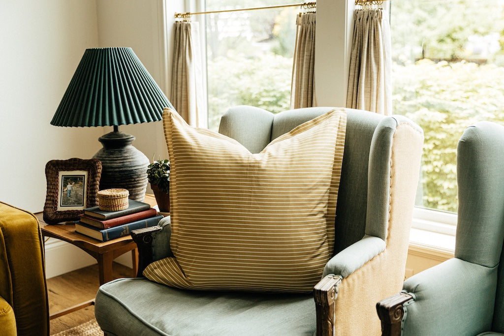 Yellow striped xl euro pillow on chair in home. 