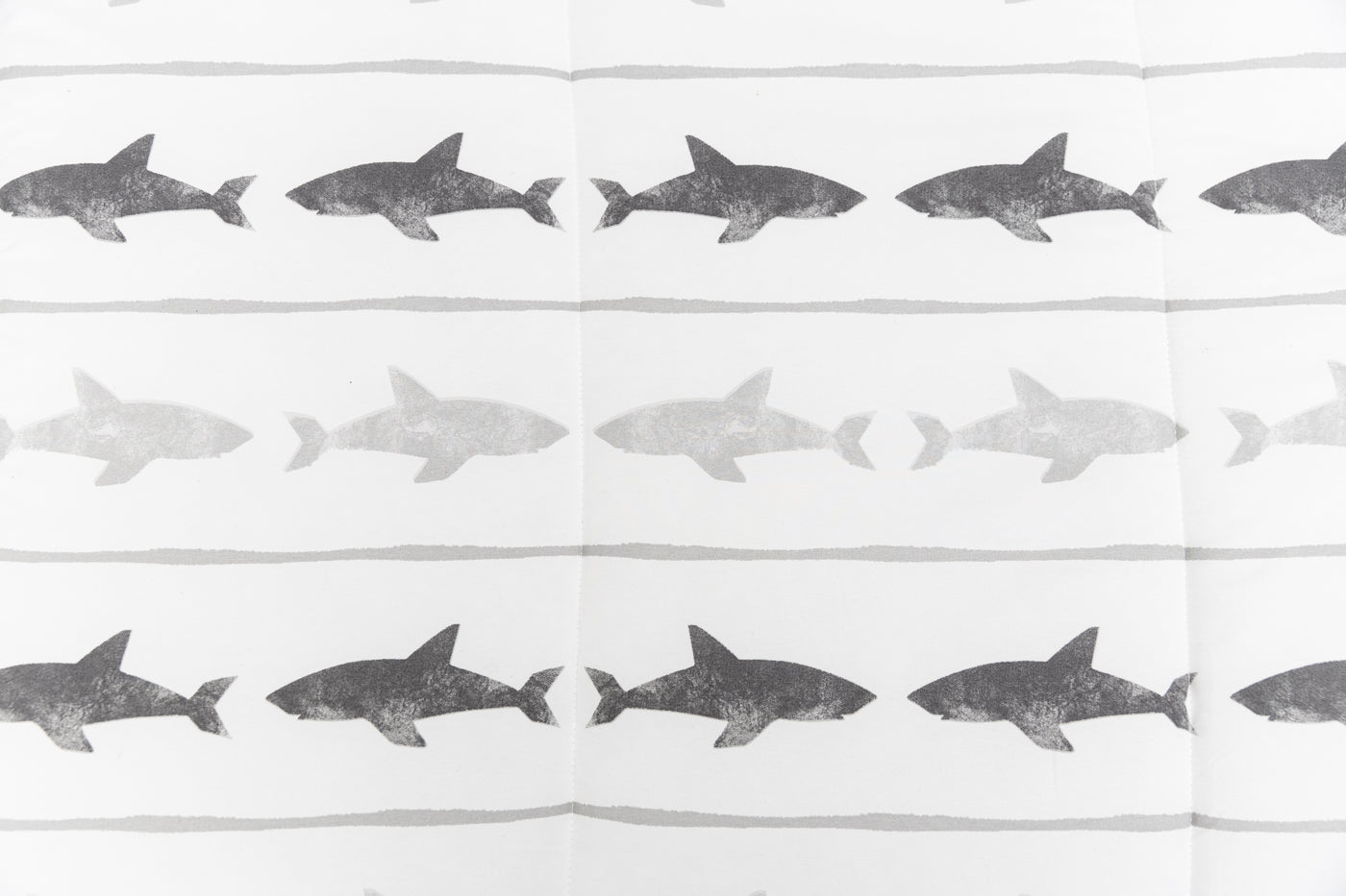 A close up of the shark print on a set of shark kids zipper bedding