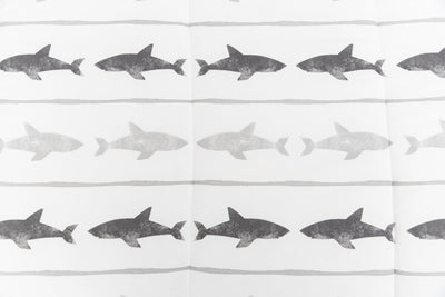 A close up of the shark print on a set of shark kids zipper bedding