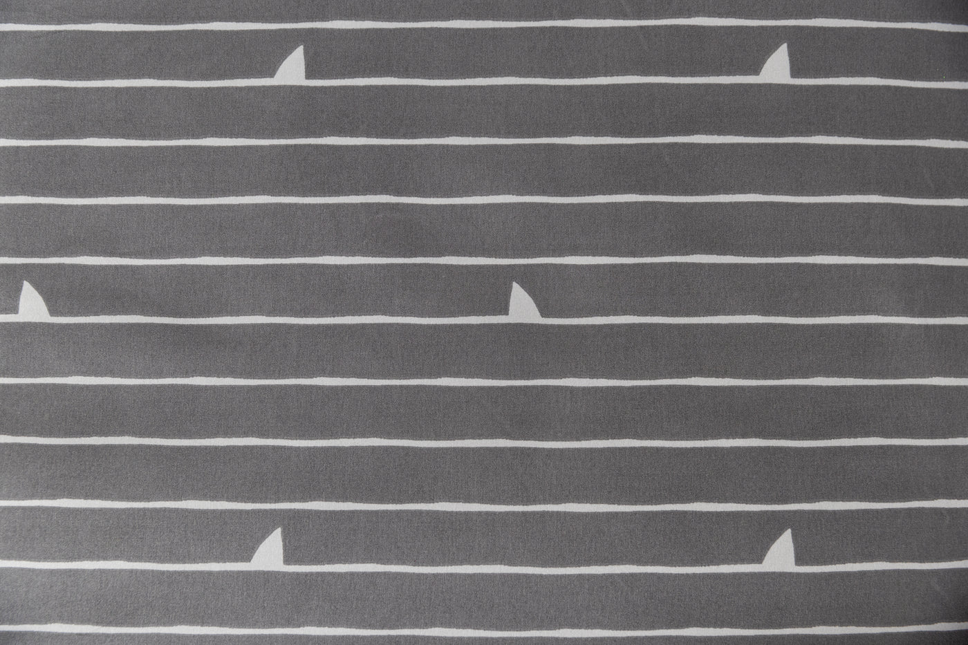 A close up of the interior print on a set of shark kids zipper bedding