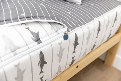 A close up of the zipper feature on a set of shark kids zipper bedding