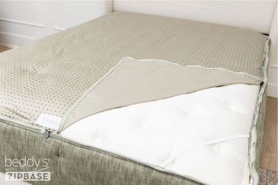 A ZipBase sheet partially unzipped and pulled back to show how it detaches from the rest of the base sheet wrapped around the sides of the mattress.