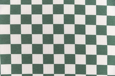 A close up view of a white and green checkered printed blanket.