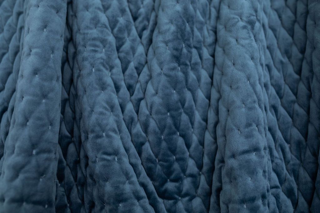 A close up view of a dark blue velvet blanket.