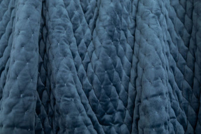 A close up view of a dark blue velvet blanket.