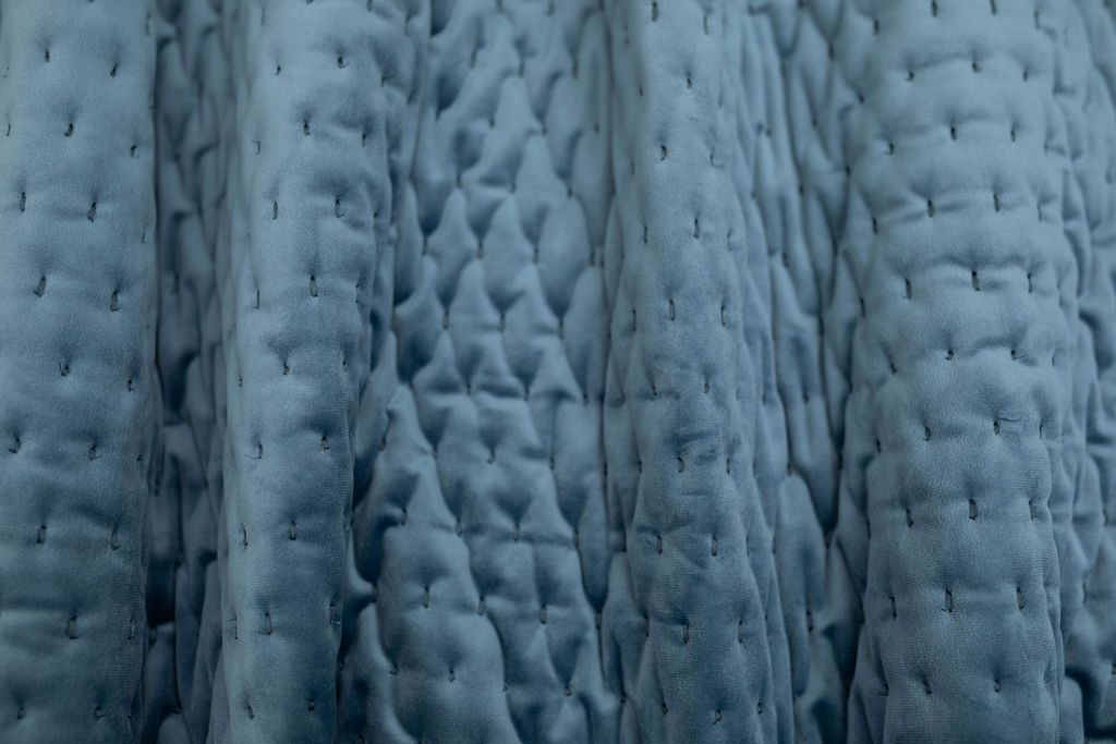 A close up view of a blue velvet blanket.