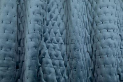 A close up view of a blue velvet blanket.