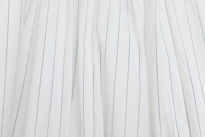 A close up of a white and light thin blue striped blanket.