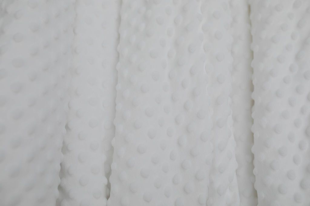 A close up of a white softly textured minky blanket.