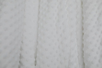 A close up of a white softly textured minky blanket.