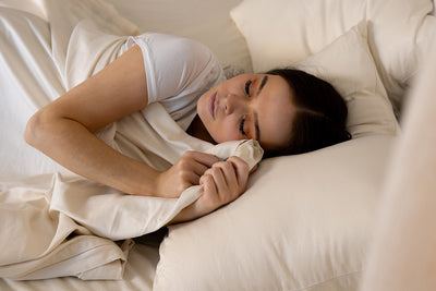 A person cuddling with zipper sheets in a bed.