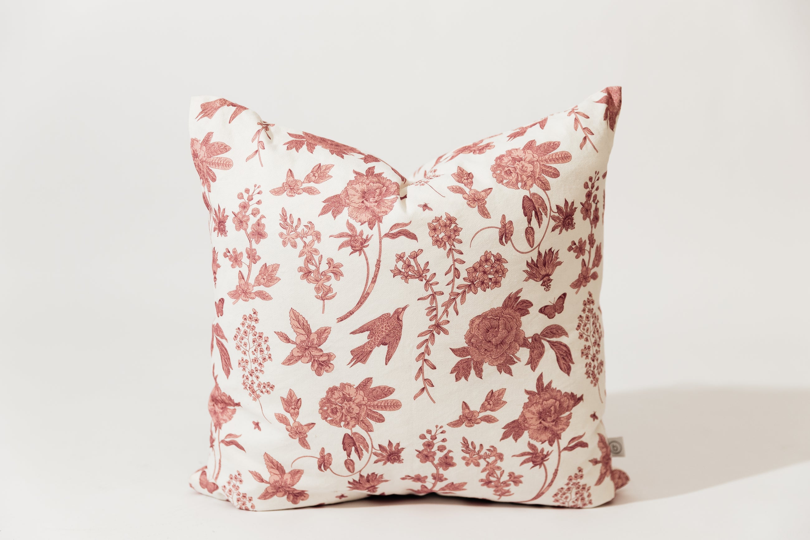Medium pillow on white background with white and floral pattern